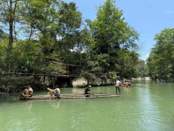 Bamboo raft floating peacefully on the river at Ngoc Long village in Ha Giang, surrounded by lush greenery