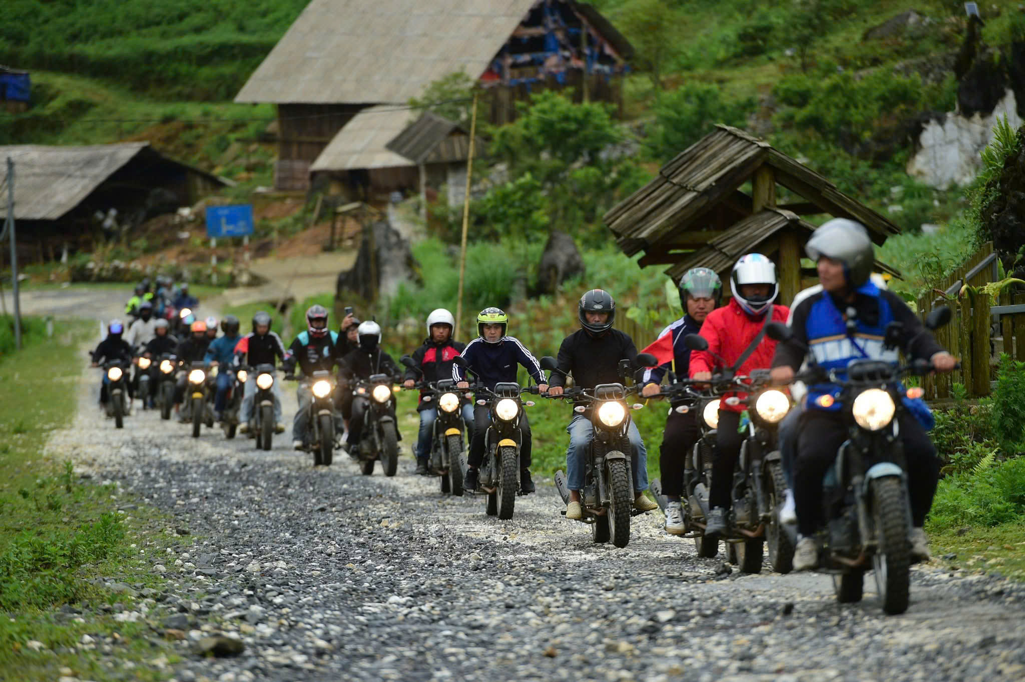 Ha Giang travel guides – tourists riding motorbikes along winding mountain roads in northern Vietnam