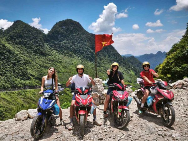 Travelers stop their motorbikes to take photos of the Ha Giang mountains during the motorbike tour