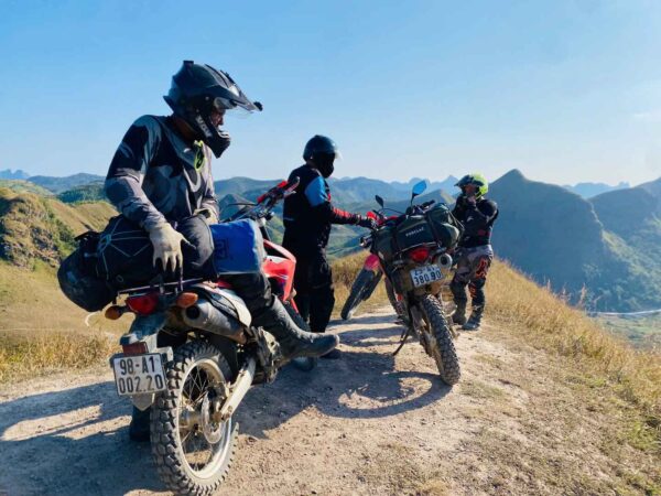 Motorbike riders navigating a rocky off-road trail in the mountains of Ha Giang, Vietnam