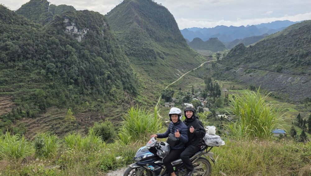 Two riders on a scenic mountain road of