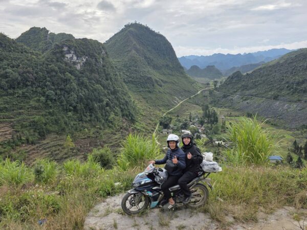 Two riders on a scenic mountain road of
